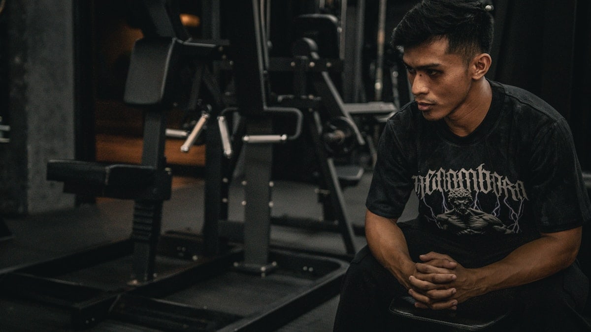 A man sitting on a bench in a gym